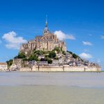 Mont Saint Michel rises majestically from the sea, showcasing its medieval architecture against the backdrop of Normandy, France.