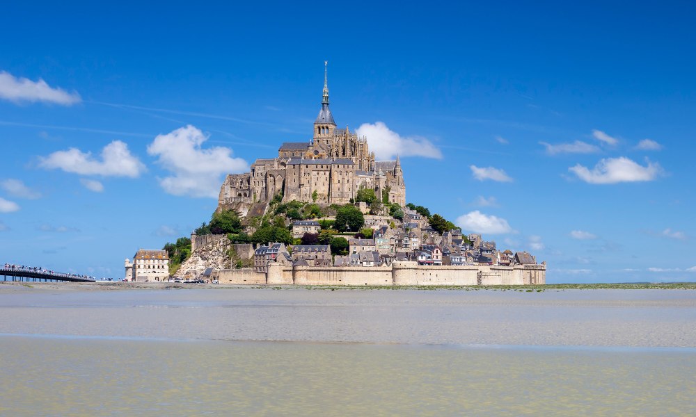 Mont Saint Michel rises majestically from the sea, showcasing its medieval architecture against the backdrop of Normandy, France.