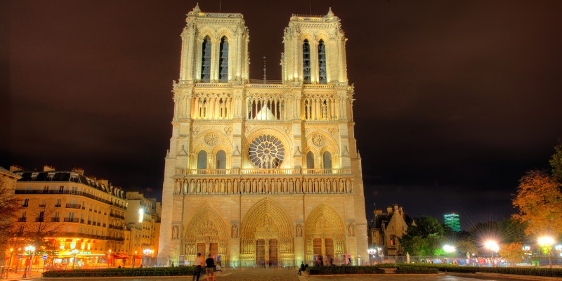 A beautiful night view of Notre-Dame Cathedral in Paris, featuring its majestic towers glowing under the night sky.