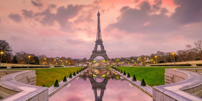 A view of the Eiffel Tower from Trocadéro Gardens, showcasing the iconic landmark against a clear sky in Paris, France.