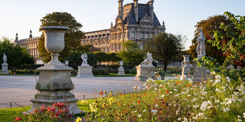 The Louvre, an exquisite building in Paris, elegantly framed by the lush Tuileries Gardens.