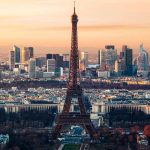 Paris cityscape at sunset featuring the Eiffel Tower, showcasing vibrant colors and iconic architecture.