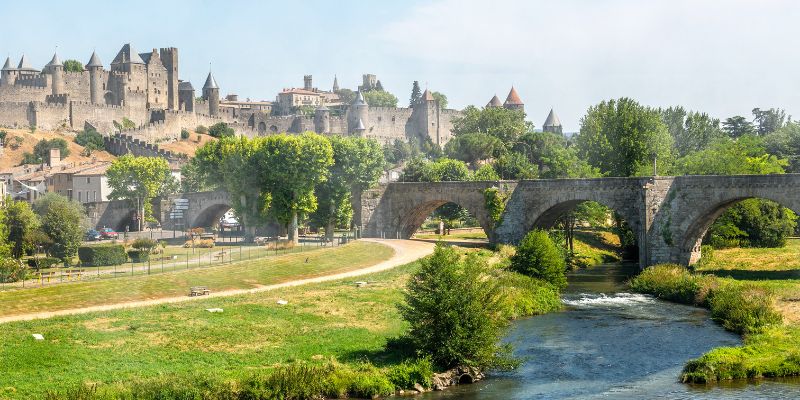 Winter scene from a train showing a bridge over a river in Carcassonne, highlighting the serene landscape.