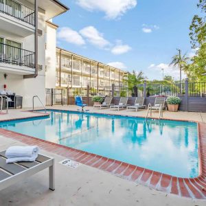 The inviting pool area at the Holiday Inn in San Diego, featuring clear blue water and comfortable seating for guests.