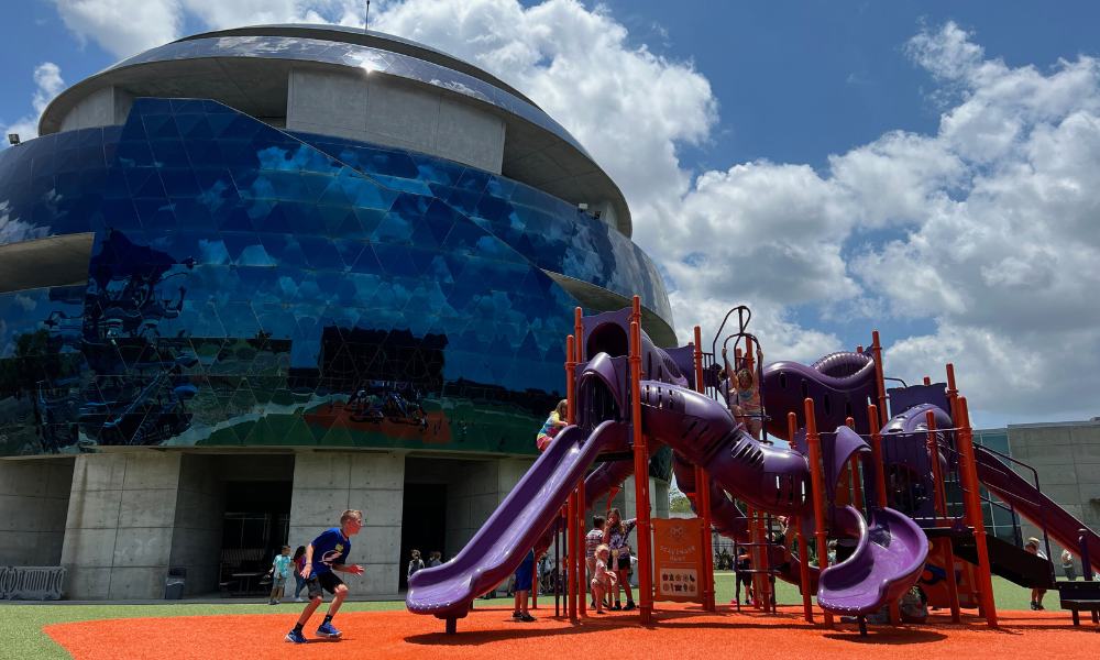 Playground at the Museum of Science and Industry featuring a slide and a nearby building.