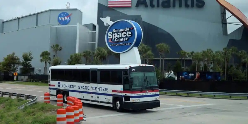 A bus drives by the NASA Space Center, showcasing the Kennedy Space Center Visitor Complex.