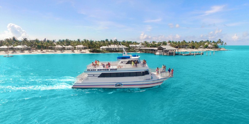 A glass bottom boat navigates the stunning blue waters of Dry Tortugas National Park, revealing underwater views.