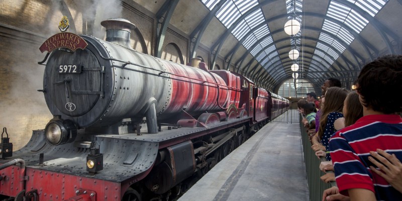 Visitors gaze at the Hogwarts Express as it departs from the station in Universal Studios Florida.