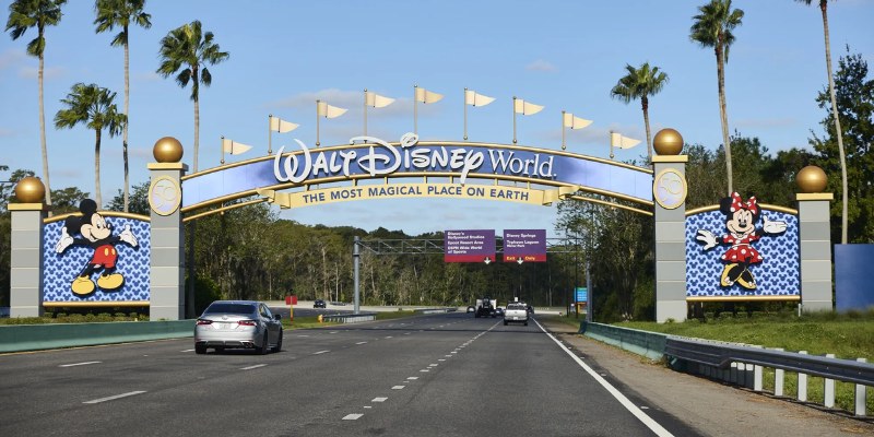 The entrance to Walt Disney World is bustling with cars, inviting guests to start their adventure.