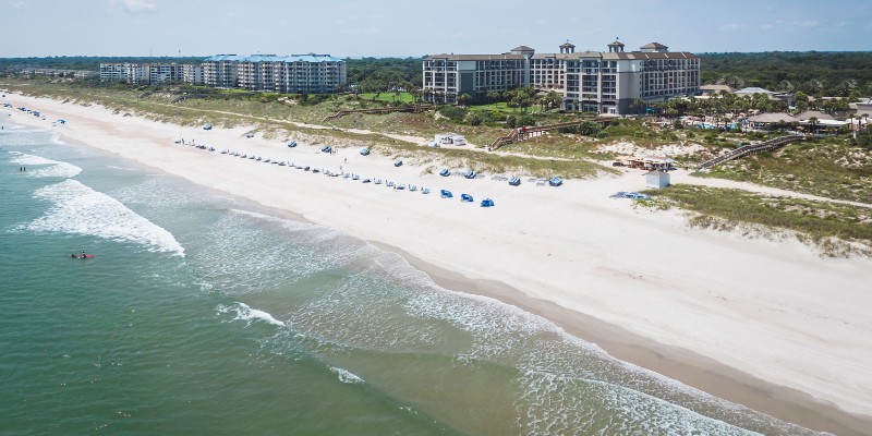 Top-down view of Amelia Island capturing the beach and ocean, with resort facilities positioned along the sandy coast.