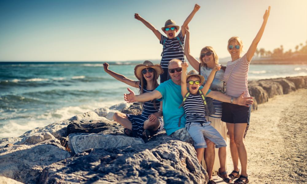 Parents and children laughing together on the beach, surrounded by sand and water, are ideal for family vacations in Florida.