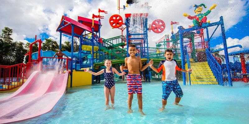 A group of kids playing in the water at LEGOLAND Florida's water park, laughing and having fun.