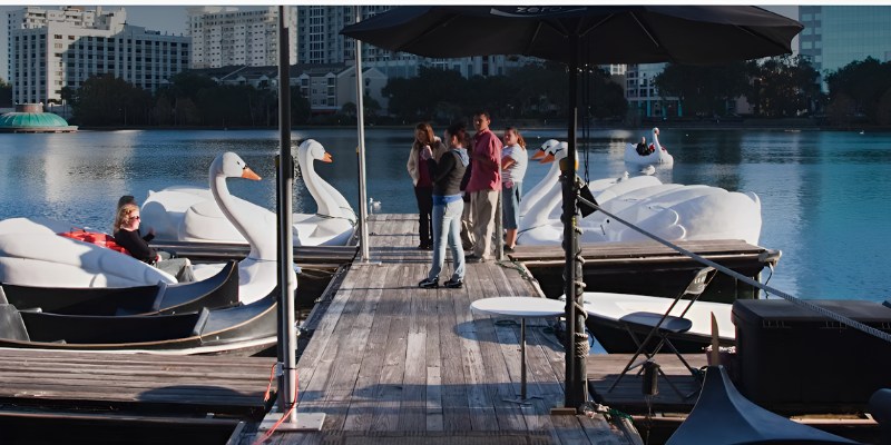 People on a dock near swan boats at Lake Eola Park in Orlando.