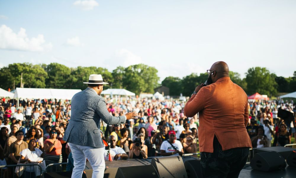 Two performers engage a large, excited crowd at the outdoor MOMENTUM (BAMS Fest) event.