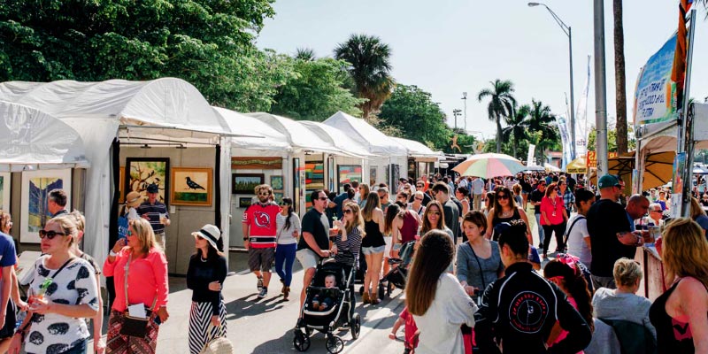 An outdoor art festival with many tents and visitors.