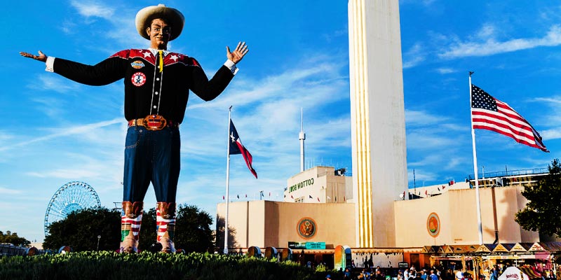 The giant Big Tex statue stands with arms open at Fair Park near the Cotton Bowl, welcoming guests to the State Fair of Texas.