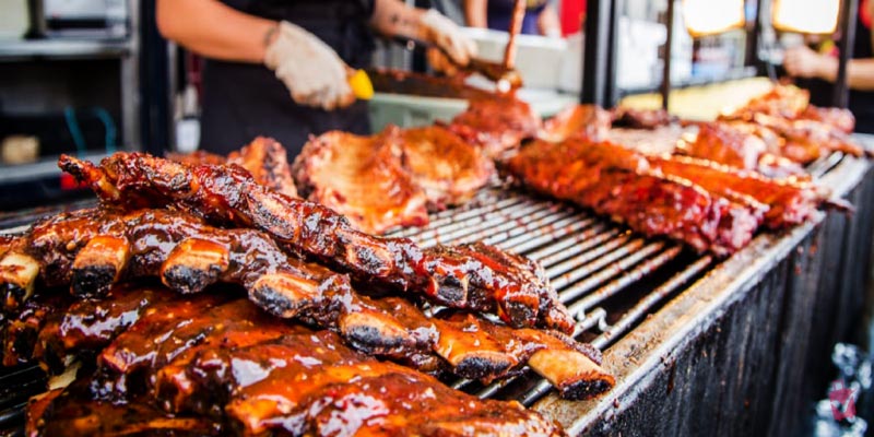 Stacks of glistening sauced barbecue ribs are prepared on large outdoor grills for the American Royal World Series of BBQ competition.