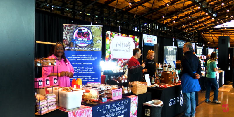 A vendor smiles behind a display of goods at the Chocolate Wine and Whiskey Festival in Philadelphia.