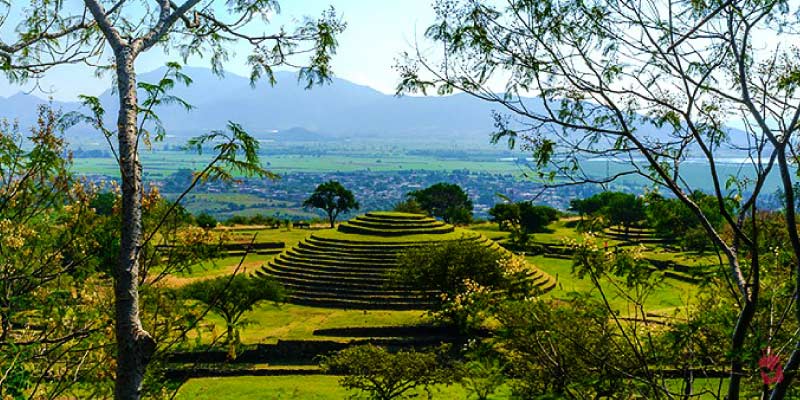 The ancient Guachimontones Archaeological Site in a lush green landscape with tiered circular pyramids, near Guadalajara.
