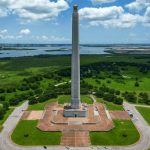 An aerial perspective shows the San Jacinto Monument standing tall among green fields as one of the most Iconic Historical Landmarks in Houston.