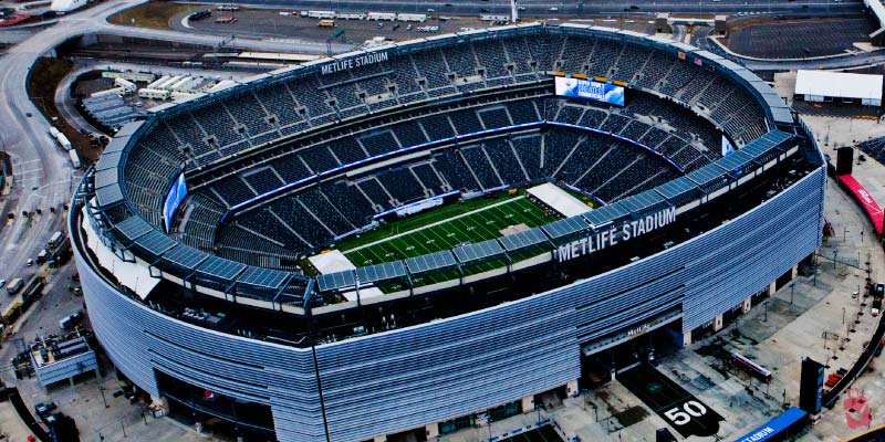 An expansive aerial shot of MetLife Stadium shows the massive seating area and green field of this premier sports and entertainment venue.