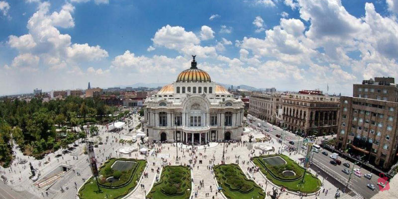 Palacio de Bellas Artes, a grand domed palace at a busy intersection in Mexico City, is a cultural landmark.