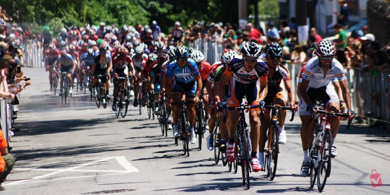 A pack of cyclists races downhill on a sunny day during the Philadelphia Cycling Classic.