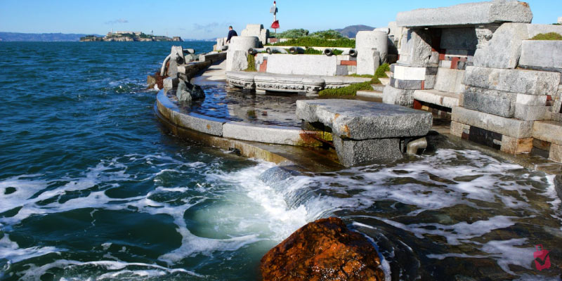 Sea waves crash against the stone pipes of The Wave Organ, an acoustic sculpture on the San Francisco shoreline.