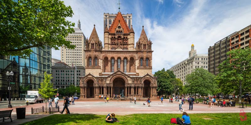 The ornate Romanesque architecture of Trinity Church stands tall in Copley Square, serving as a beautiful architectural landmark in the heart of Boston.
